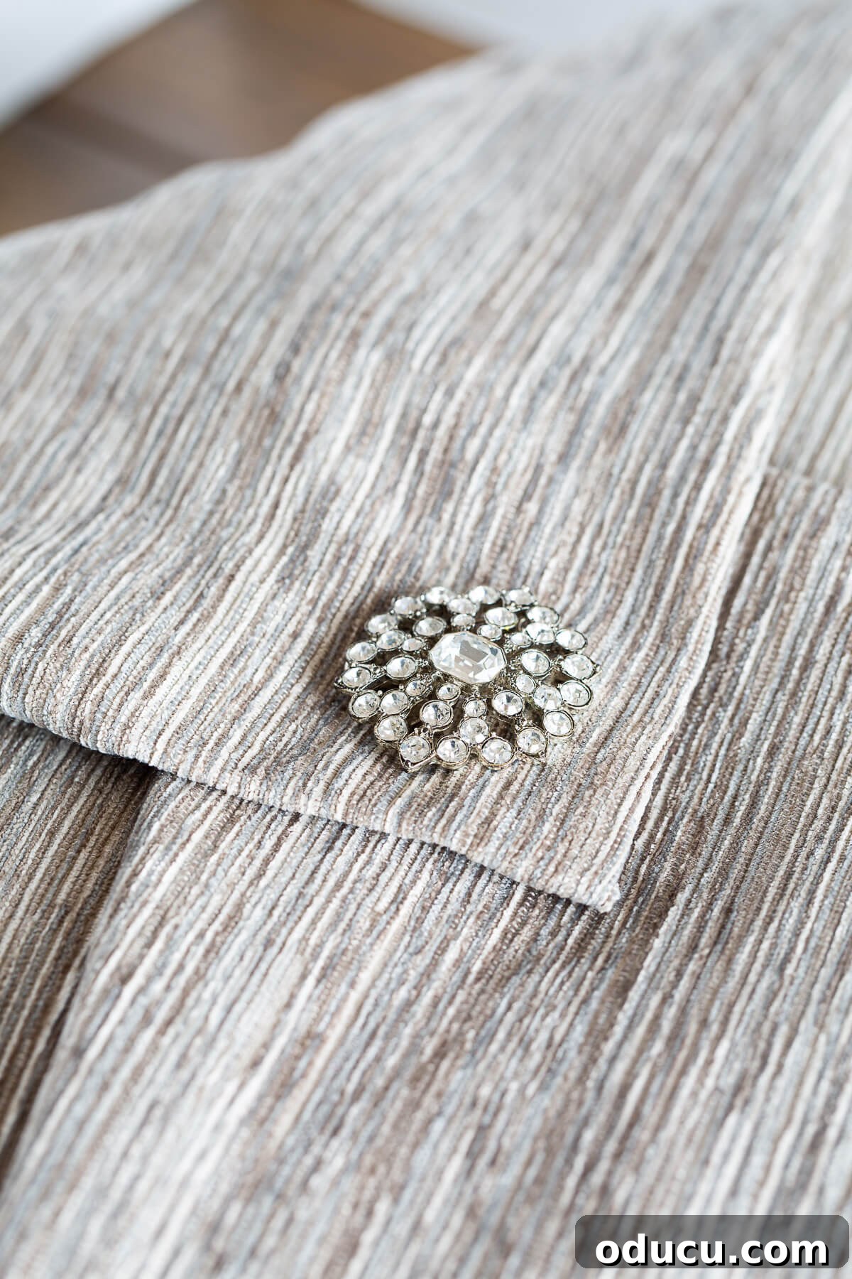 close up of a no zipper pillow cover to make with a pretty pin embellishment.