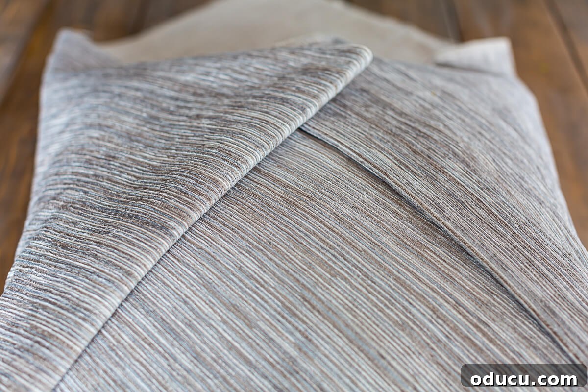 Folded edges of fabric on no sew envelope pillow.