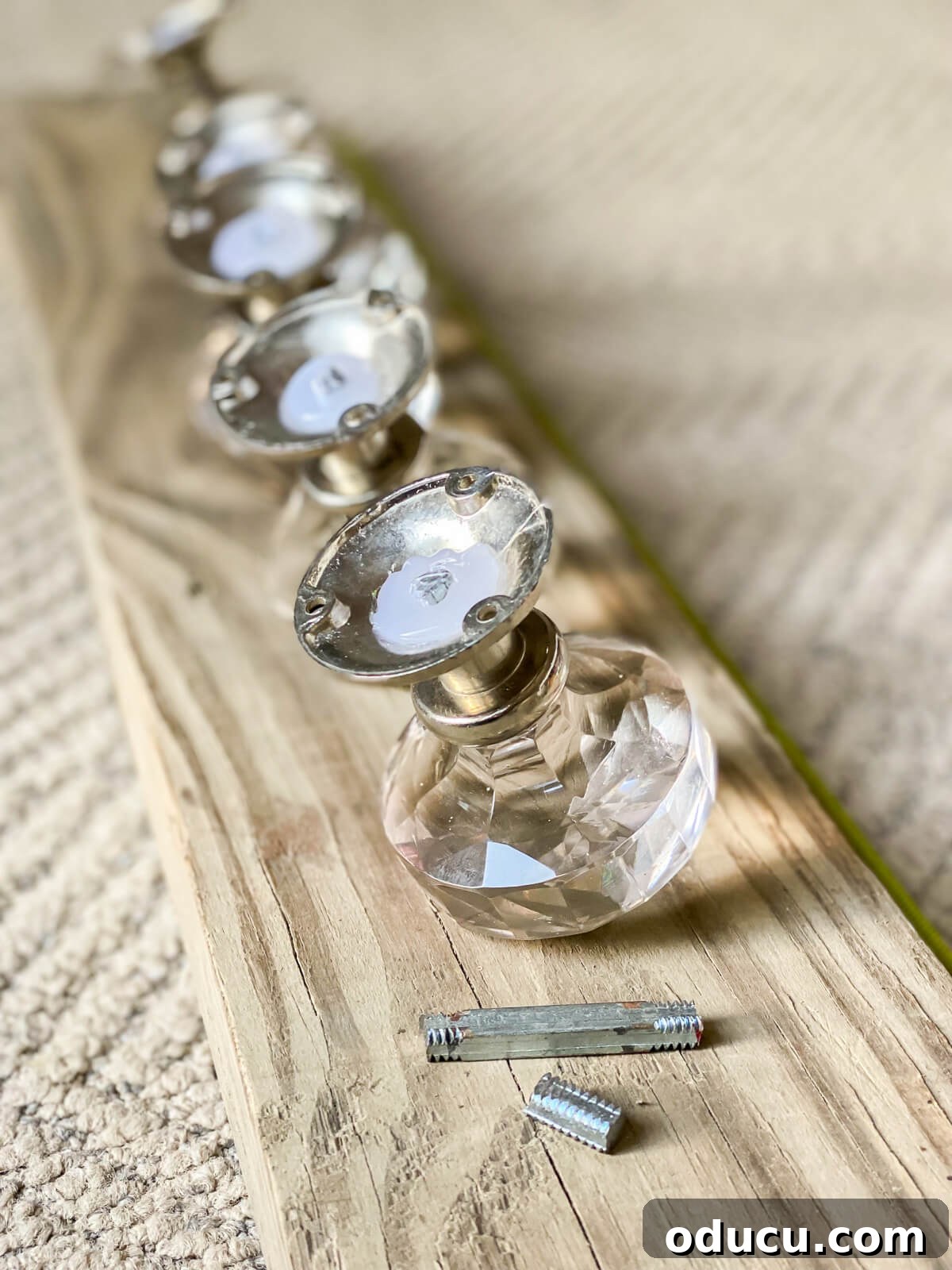 back side of glass doorknobs being ready to attach to wood board.