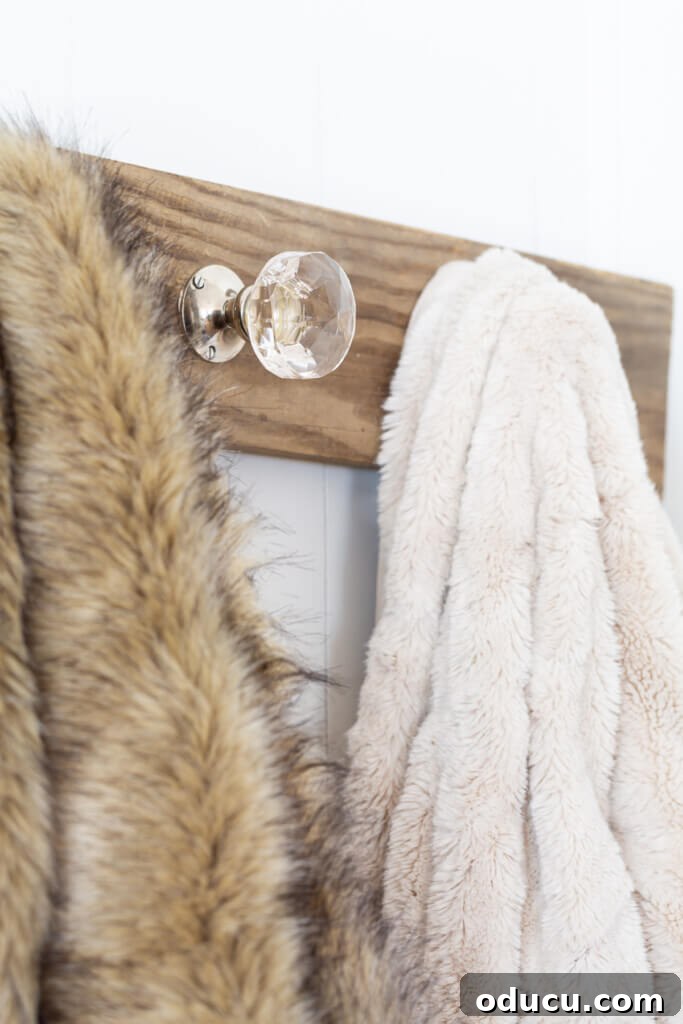 Elegant Wall Organizer for Living Room Throws 8 Close up of glass door knob mounted on board to hold throw blankets or quilts.