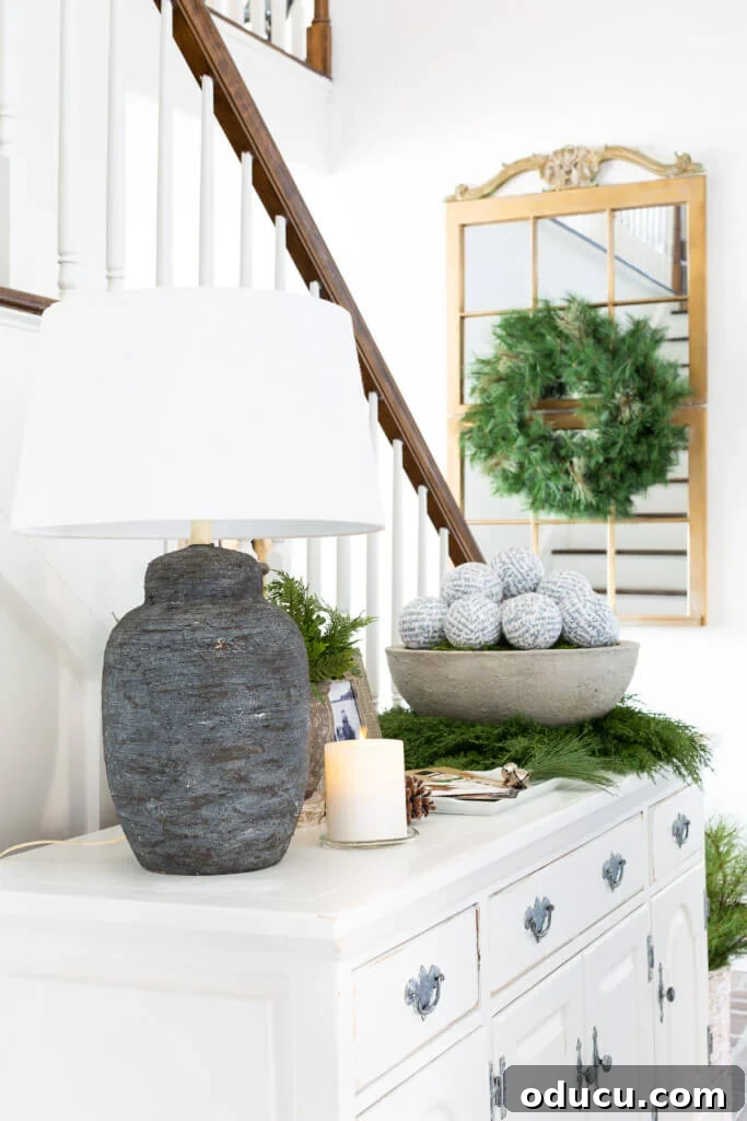 Festive Without the Fuss: Our Christmas Home Tour 11 A serene entryway, tastefully decorated for Christmas with a focus on natural textures and understated elegance.