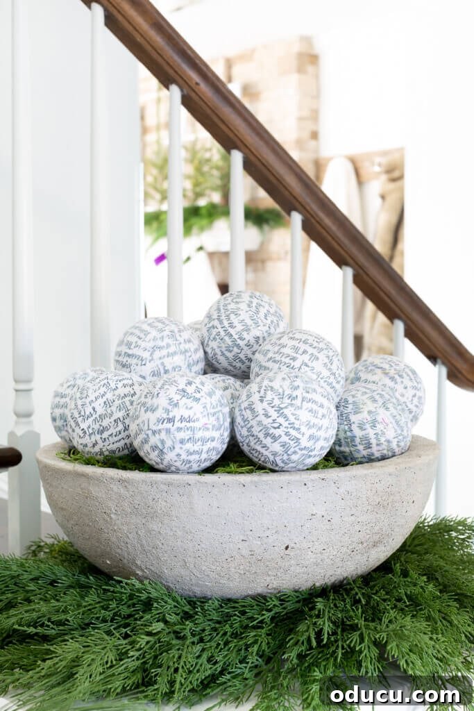 Festive Without the Fuss: Our Christmas Home Tour 12 A large, decorative bowl filled with an abundance of unique, paper-wrapped ball ornaments, creating a rich visual texture.