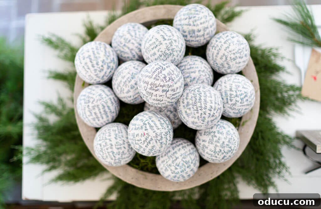 Festive Without the Fuss: Our Christmas Home Tour 16 A close-up view looking down into a large decorative bowl filled with ball ornaments beautifully covered in script paper, showcasing intricate detail.