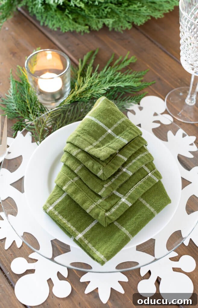 Festive Without the Fuss: Our Christmas Home Tour 21 A vibrant green napkin artfully folded into the shape of a Christmas tree, adding a whimsical and festive touch to the table.