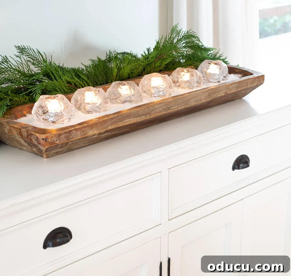 Festive Without the Fuss: Our Christmas Home Tour 7 Kosta Boda snowball candles arranged elegantly in a long wood dough bowl, creating a soft, ambient glow.