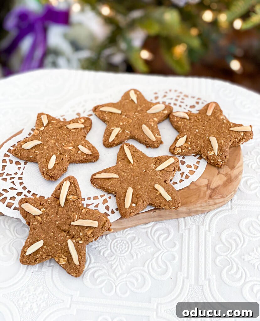 Spiced & Sweet Vegan Gingerbread Cookies 4 Vegan Christmas cookies on a doily in front of a Christmas tree.