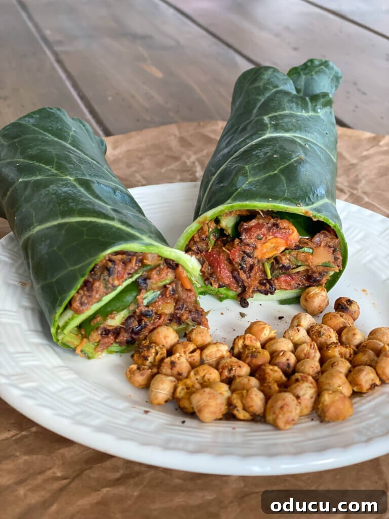 Effortless Vegan Collard Green Wraps 3 A vegan collard green wrap cut in half on a plate with roasted chickpeas.