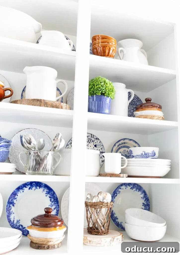 Open Kitchen Shelving: Cabinet Door Removal 21 Open white shelves in kitchen decorated with blue, white and brown items.
