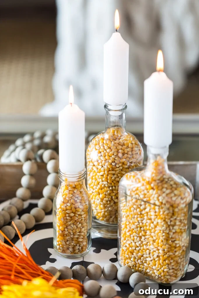 Unlock New Decor Ideas for Candle Holders 25 DIY Fall candle holders crafted from glass food bottles, filled with unpopped popcorn kernels, for a seasonal touch.