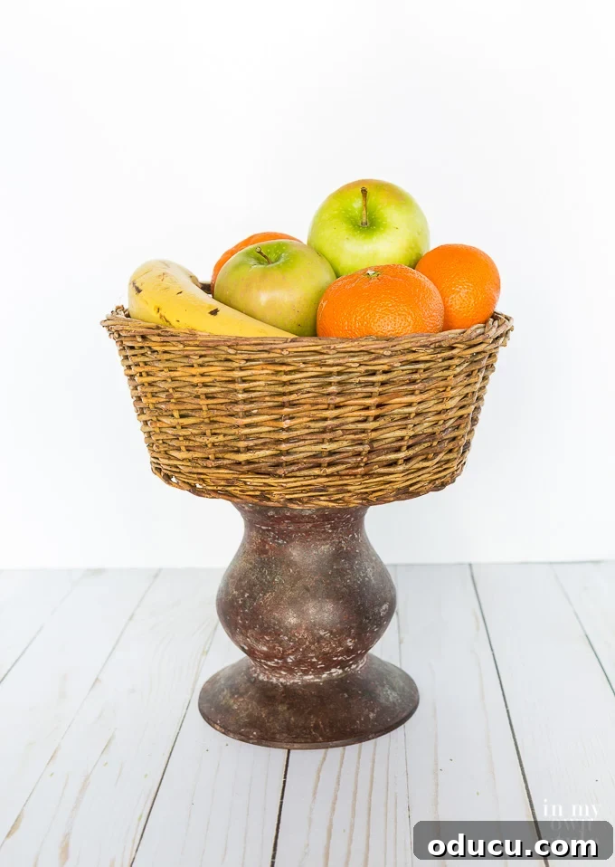 Unlock New Decor Ideas for Candle Holders 9 A rustic fruit basket beautifully elevated on a pillar candle holder, showcasing creative repurposing.
