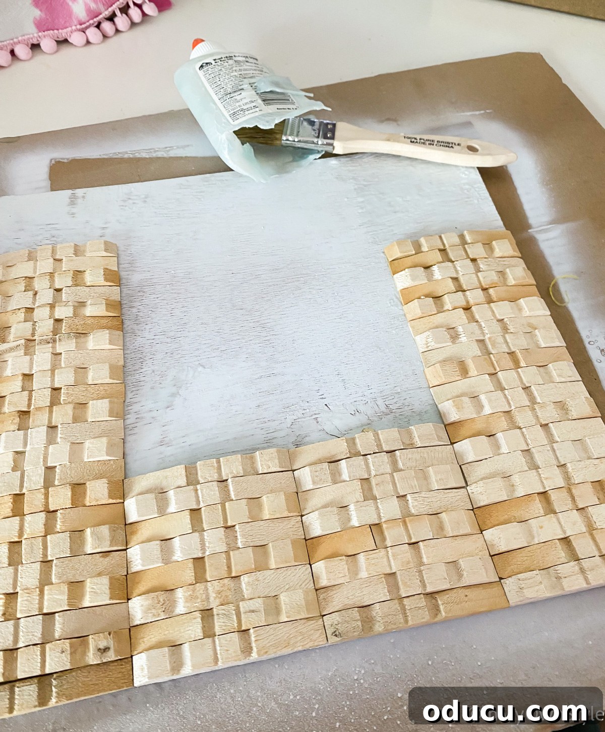 Gluing wood clothespins on plywood to make a frame.