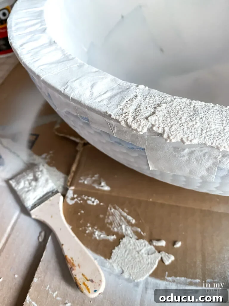 Build Your Own Tabletop Fire Pit in Minutes 3 Spreading layer of stucco patch on bowl with a paint brush.