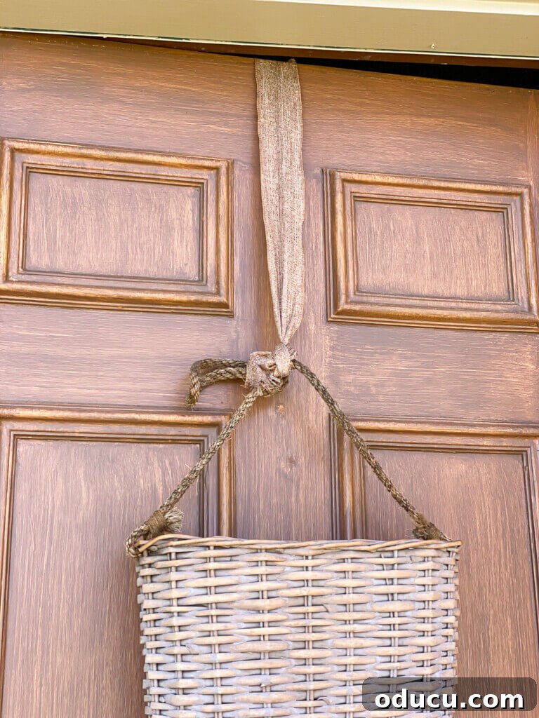 Cozy Fall Wicker Door Basket Project 13 flat sided hanging basket on exterior door hung with ribbon.