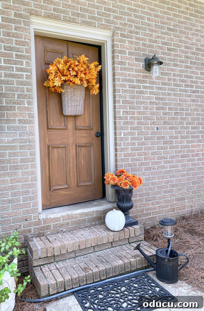 Cozy Fall Wicker Door Basket Project 10 Orange hued fall leaves in abundance in a hanging basket on an exterior door.