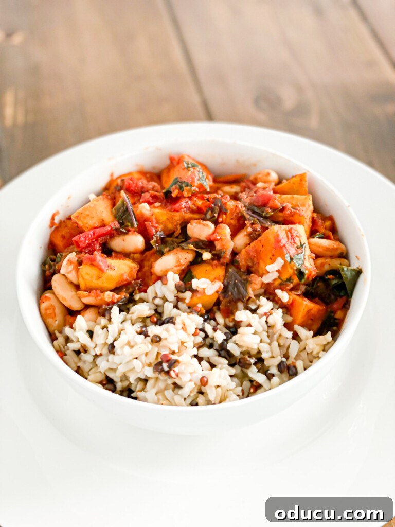 The Kale Chili You'll Make Again and Again 2 A vibrant bowl of Whole Food Plant Based Chili featuring sweet potatoes and kale, garnished with fresh herbs.