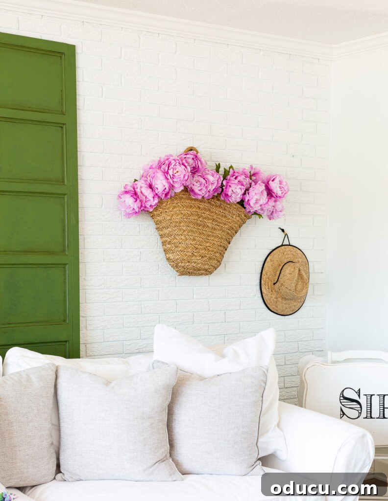 12 Affordable DIY Summer Decor Projects 17 Vibrant pink peonies elegantly displayed in a woven tote, hanging on a wall as a unique summer decorating idea.