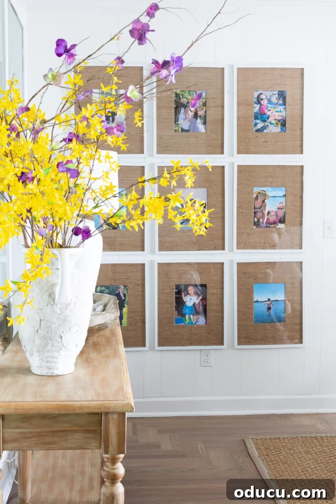 12 Affordable DIY Summer Decor Projects 8 A striking 9-grid gallery wall in a living room, featuring photo frames with grasscloth wallpaper remnant mats, adding texture and coastal charm.