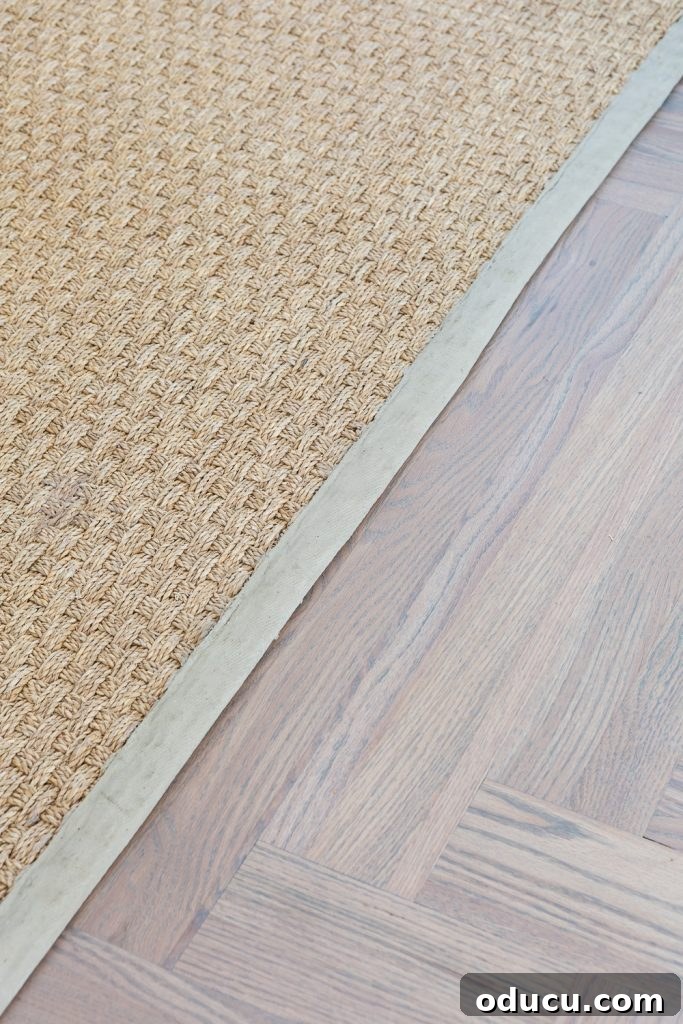 12 Affordable DIY Summer Decor Projects 10 A close-up of a seagrass rug featuring a beautifully painted beige border trim, showcasing a DIY home decor project.