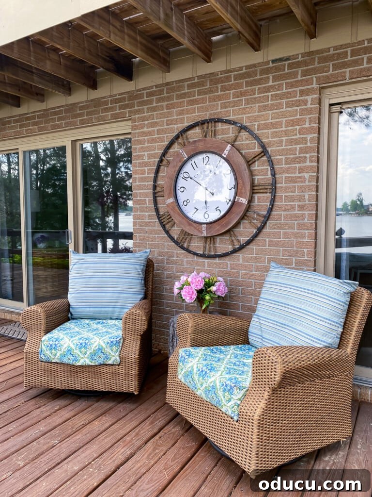 Make a Statement with Large Outdoor Clocks 11 Outdoor deck with rattan furniture and a large wall clock on the wall behind the chairs.