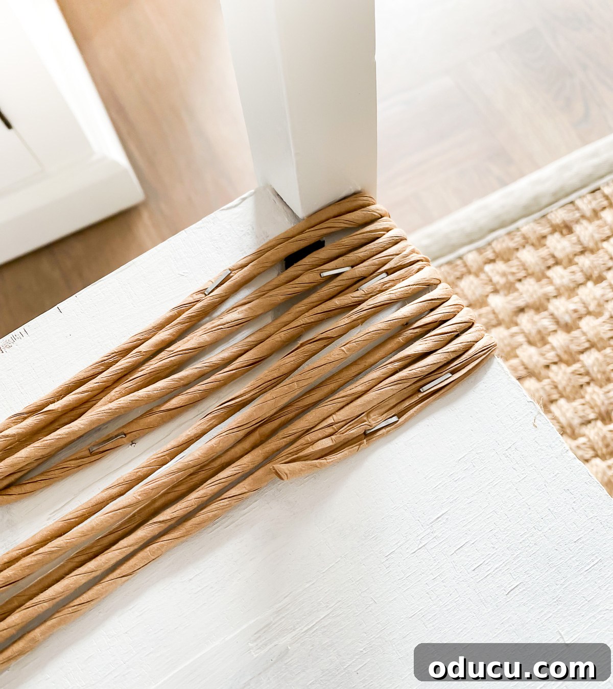 Designer Dupe Two-Tier End Table Makeover 17 Stapling the fiber rush cord to the underside of the table to begin wrapping the first layer of the woven texture on the shelf.