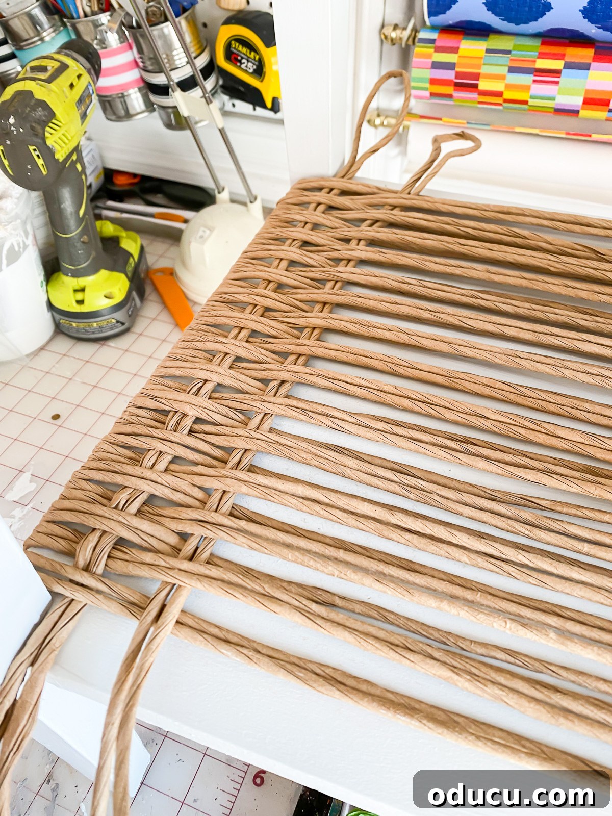 Designer Dupe Two-Tier End Table Makeover 18 Close-up demonstrating how to weave paper fiber rushing on an end table, showing the intricate basketweave pattern.