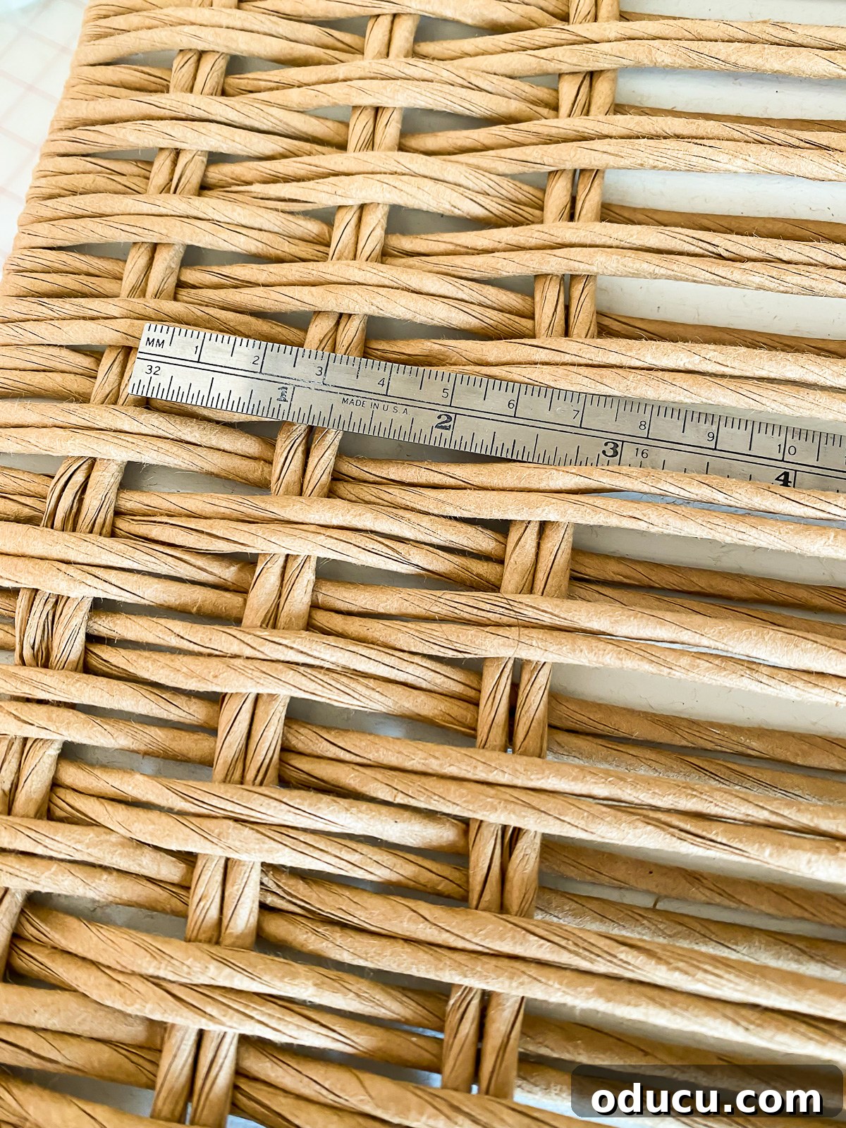 Designer Dupe Two-Tier End Table Makeover 23 Demonstration of how to space fiber rush cords evenly during the weaving process for a consistent pattern.