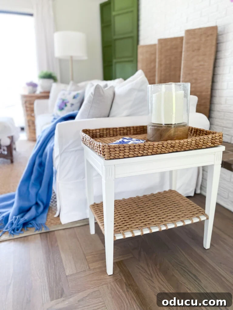 Designer Dupe Two-Tier End Table Makeover 4 Beautiful coastal style living room featuring a freshly made-over DIY end table with a white painted top and a woven bottom shelf.