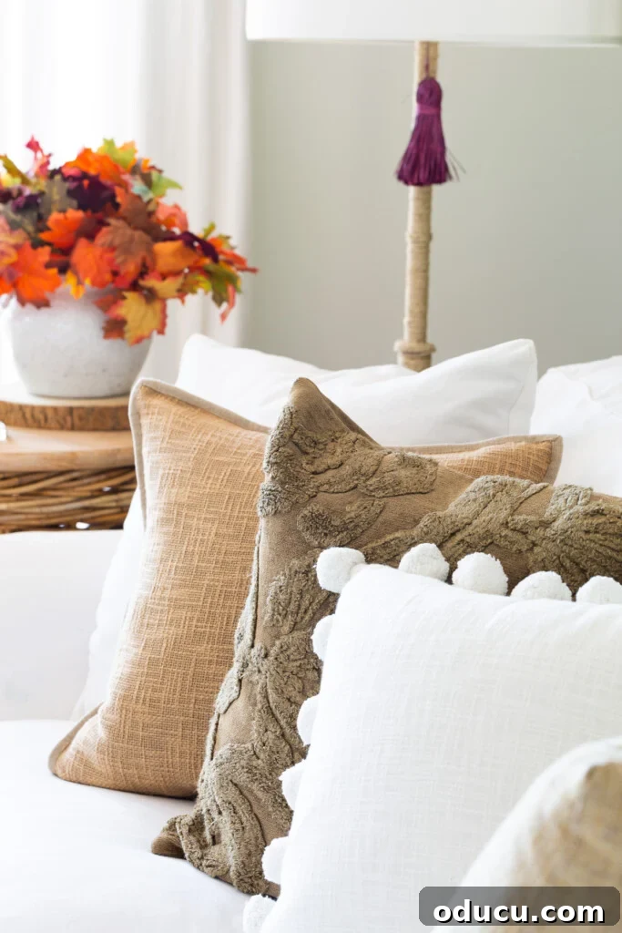 Embracing Autumn Hues in Your Living Space 2 Neutral fall colored pillows on a white sofa, creating a serene and cozy autumn atmosphere in a modern living room.