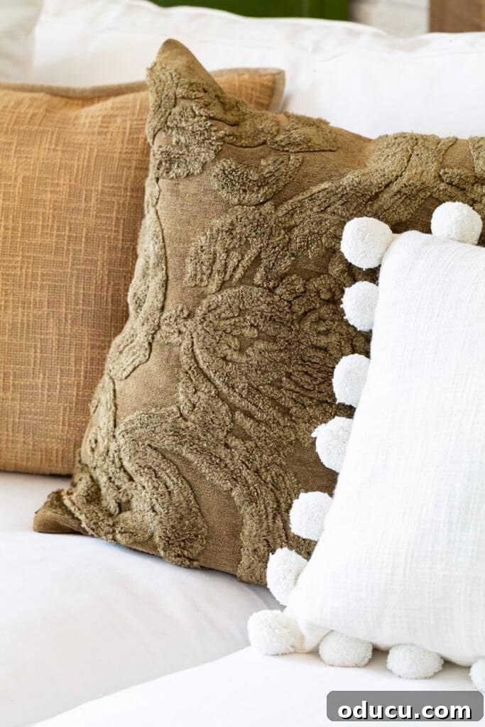 Embracing Autumn Hues in Your Living Space 13 Three fall pillows lined up on a white sofa, adding soft textures and warm autumnal hues for a cozy living room.