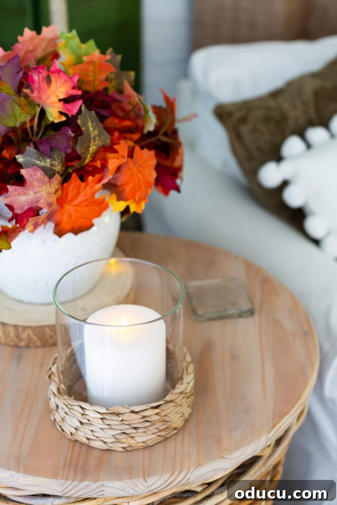 Embracing Autumn Hues in Your Living Space 7 Hyacinth hurricane candle holder on a round wood wicker side table, creating a warm and safe glow for fall evenings.