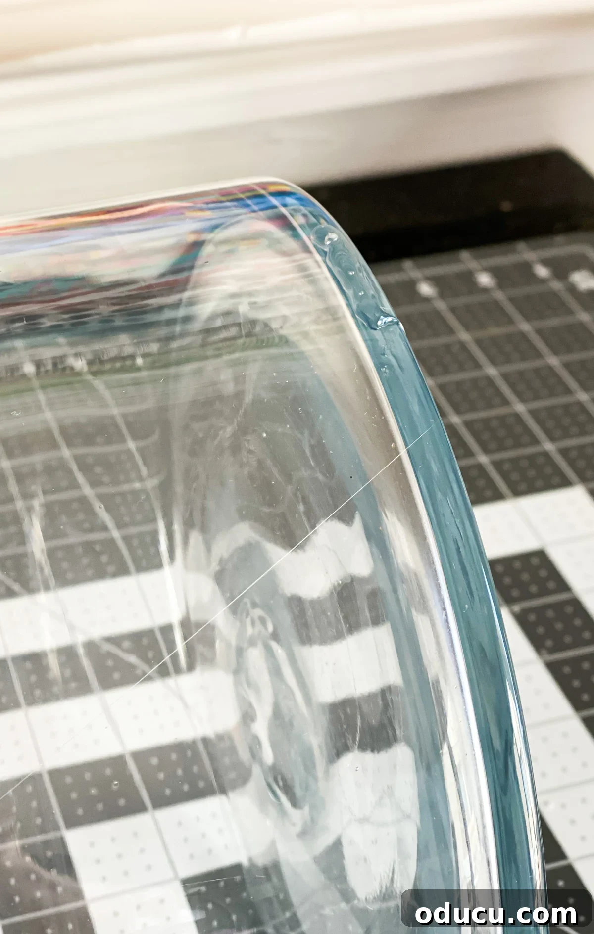 glass vase on its side with a a line of hot glue on the bottom edge