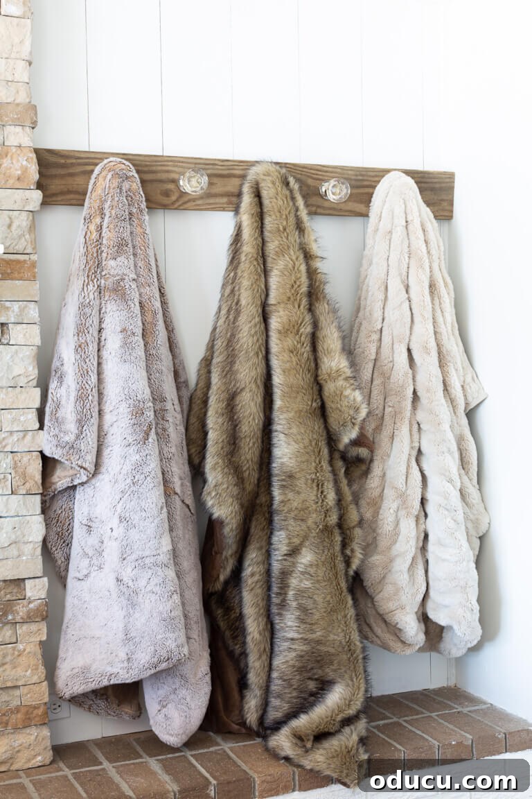 Three luxurious faux fur throws draped artfully on a blanket holder mounted on a living room wall, offering easy access to comfort.