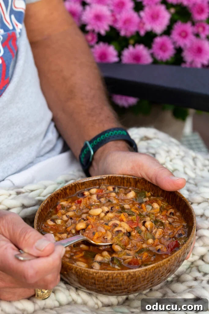 Cozy Fall Home Challenge 5 A person warmly holding a bowl of hearty Autumn Beans & Greens Soup, showcasing a comforting fall meal.
