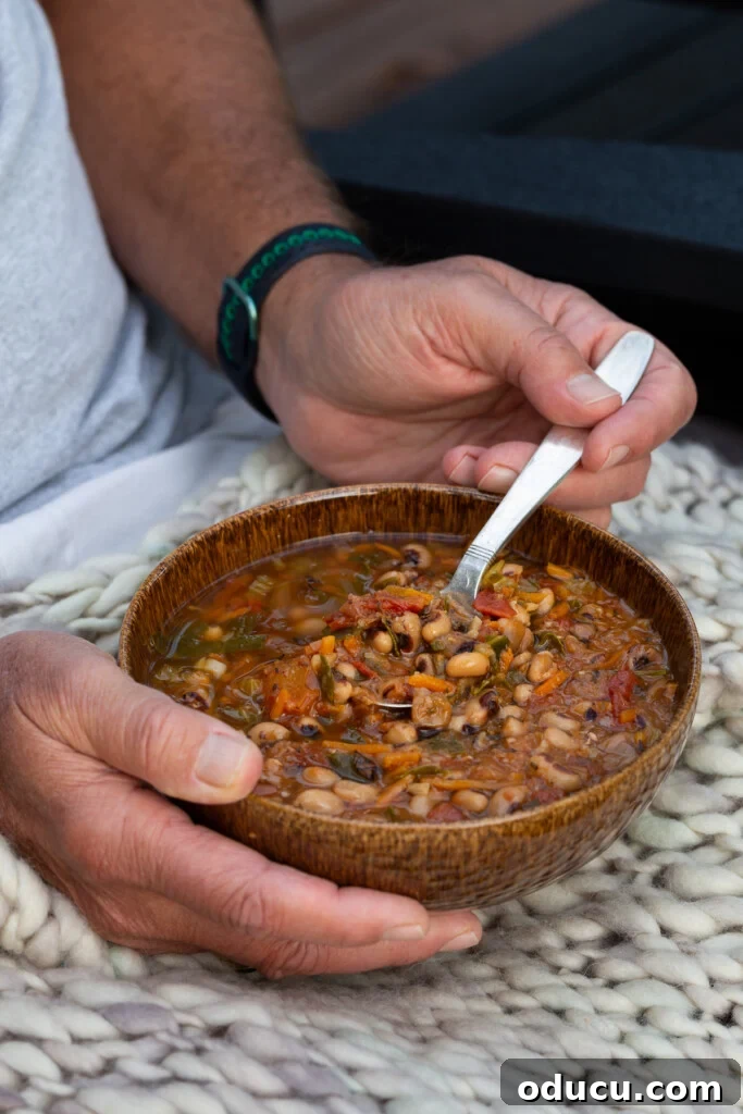 Cozy Autumn Bean and Greens Soup 6 man holding a bowl of black-eyed pea soup, ready to eat