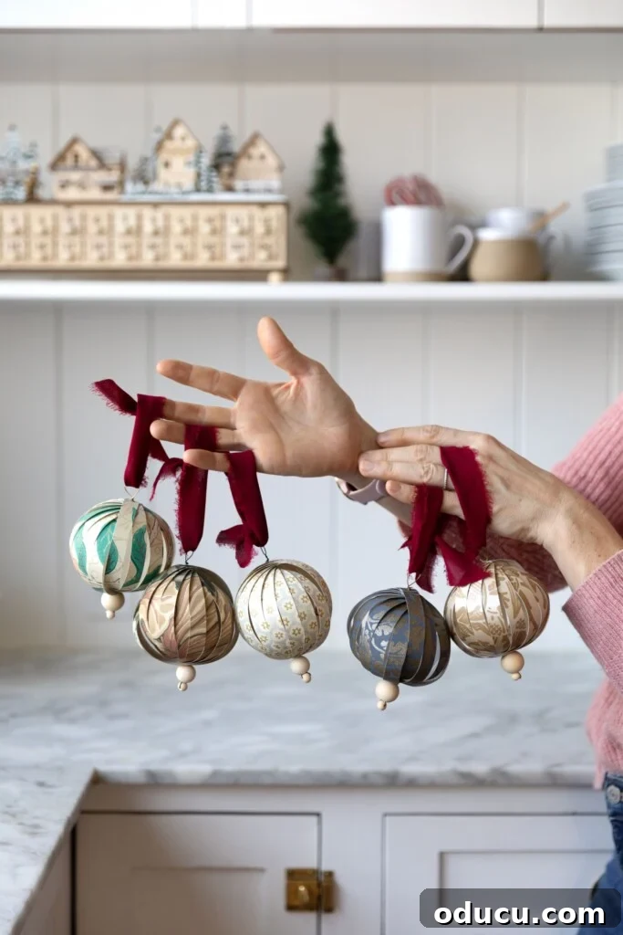 The Style Edit 2 Handcrafted Christmas ornaments made from elegant wallpaper and luxurious velvet ribbon, showcasing a sustainable and stylish approach to holiday decorating.