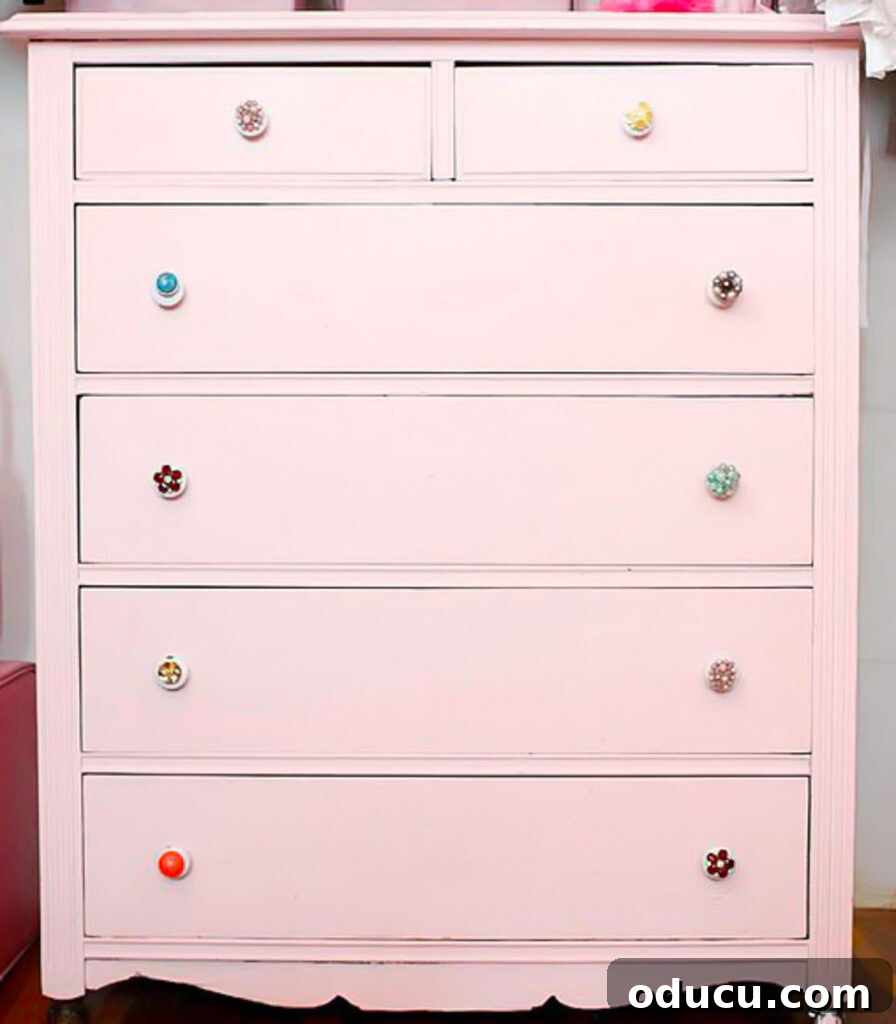 Repurpose Your Jewelry for Home Decor 11 A pink chest of drawers beautifully customized with vintage clip-on earrings serving as unique and stylish drawer pulls.