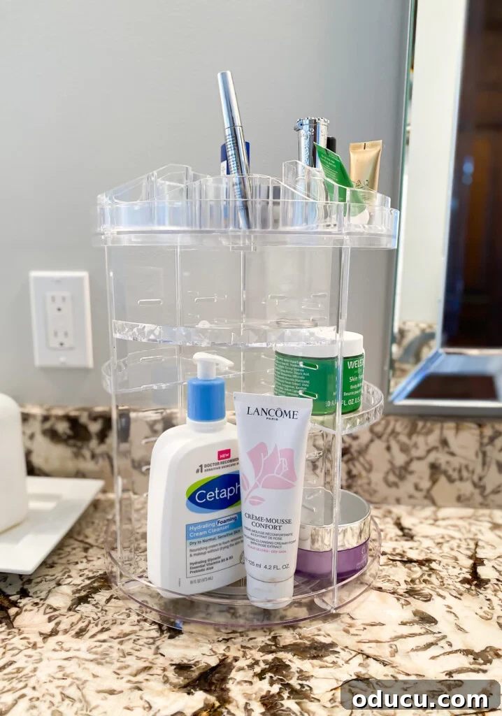 Triple-Tier Revolving Bathroom Organizer 7 A close-up of the clear acrylic bathroom organizer with various items neatly stored.