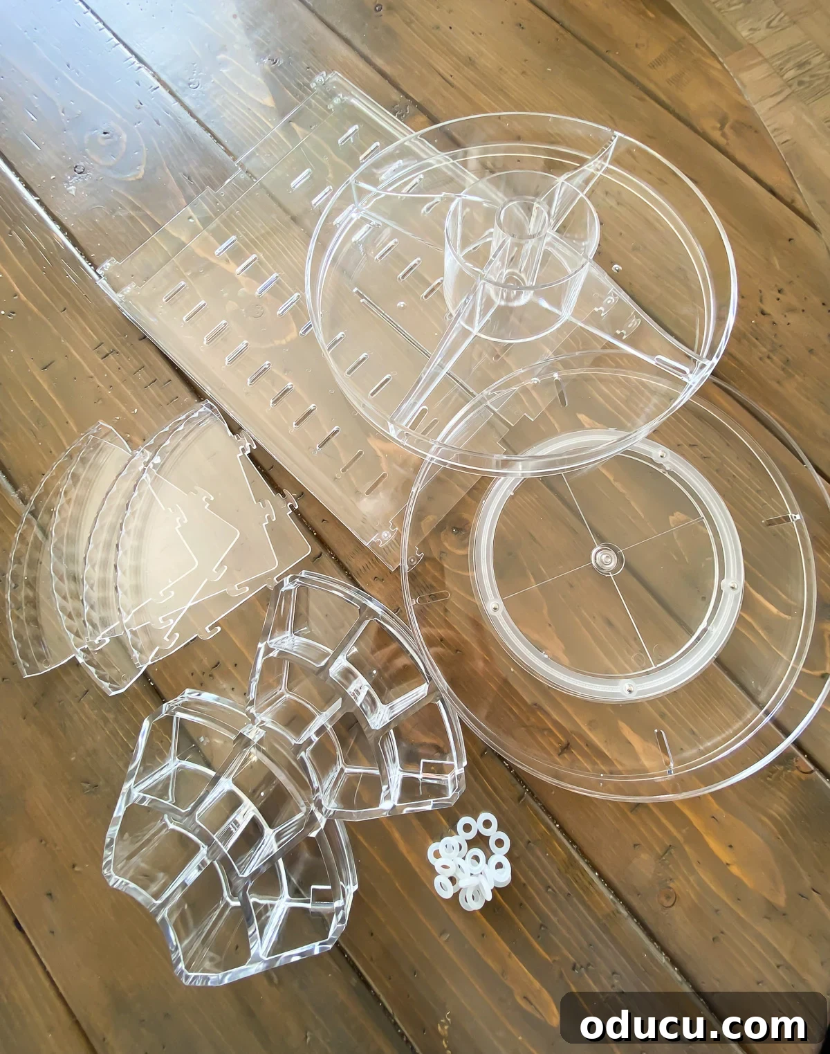 Unassembled clear acrylic bathroom organizer components laid out.