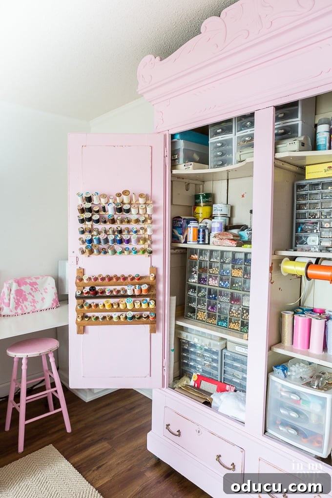 31 Clever & Chic Craft Room Ideas 7 Open large pink craft room cabinet, showcasing organized storage