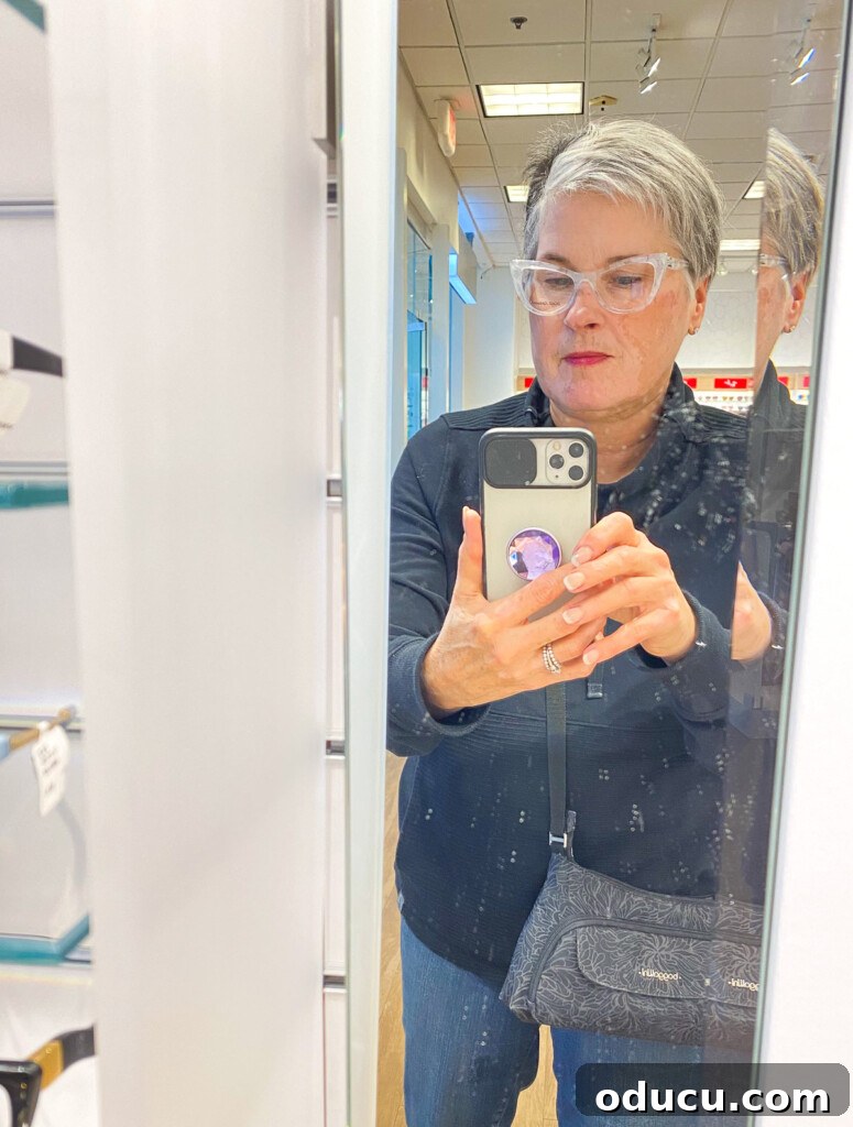 Our Teacup Talk 9 Diane from In My Own Style trying on designer eyeglasses at LensCrafters, with a slightly smudged mirror reflection.