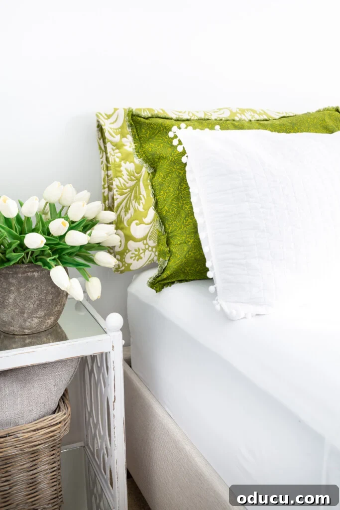 Christeli Charleston Mattress: What You Need to Know 13 3 green and white pillows on a bed with white tulips on a bedside table