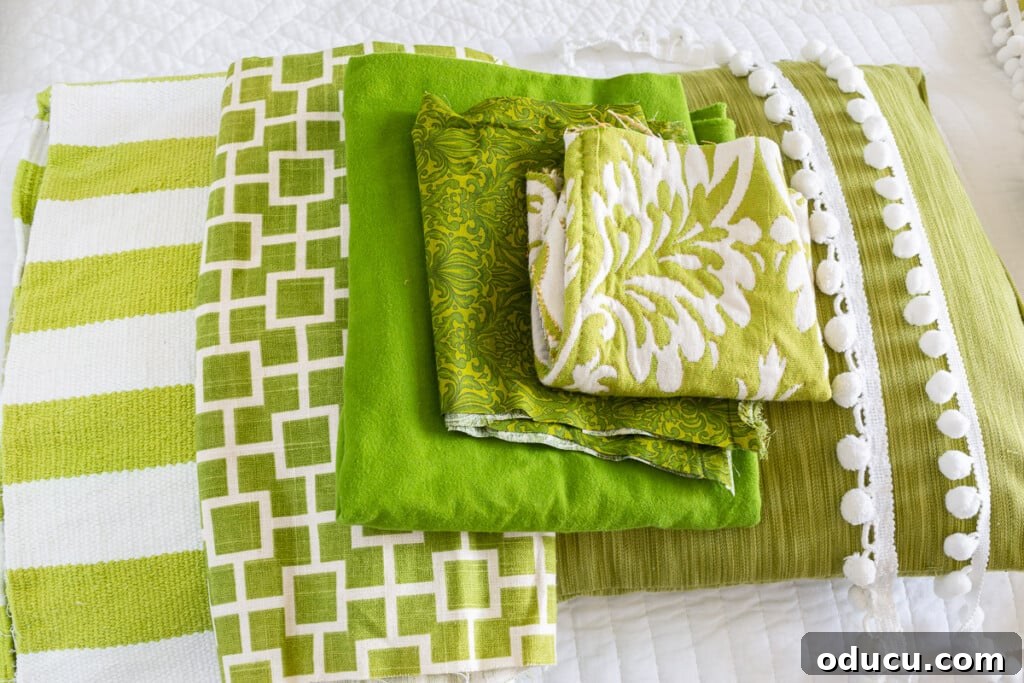 Revitalize Your Bedroom: Creative Decor Transformations 2 Close up of various green and white folded fabric yardage and textile scraps, ready for repurposing in a home decor project.