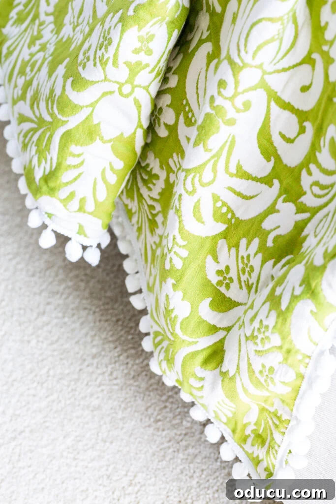 Revitalize Your Bedroom: Creative Decor Transformations 6 Close up of a striking green and white large damask patterned DIY throw blanket, showcasing intricate design and craftsmanship.