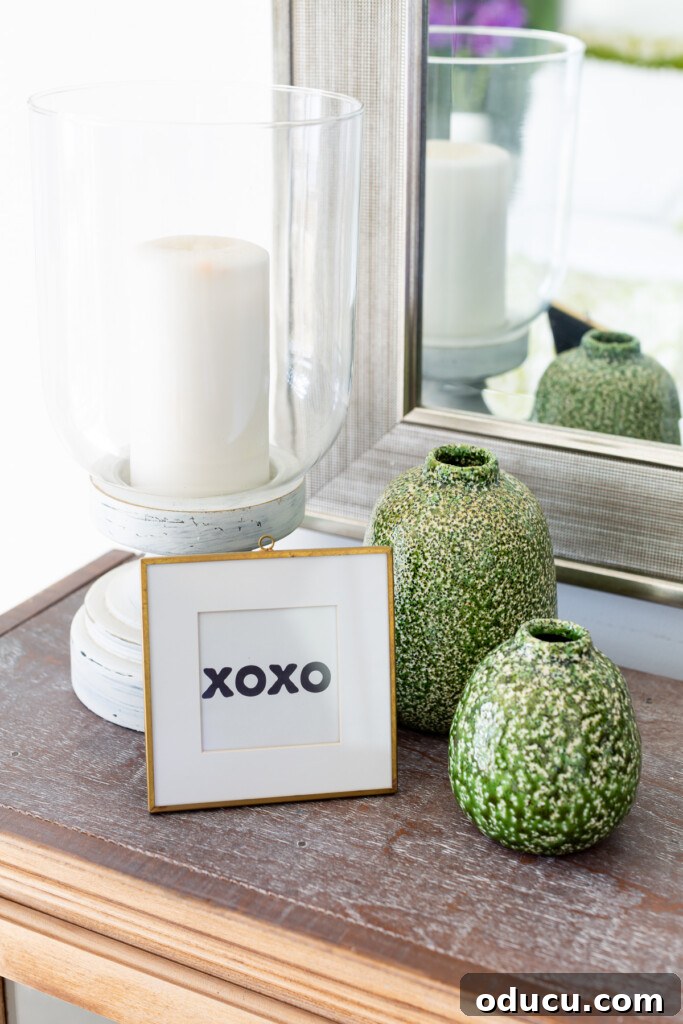 Revitalize Your Bedroom: Creative Decor Transformations 8 A charming 'XOXO' frame displayed with a collection of green and white vases and a white candle holder on a tabletop, illustrating delightful decorative accessory pairing.
