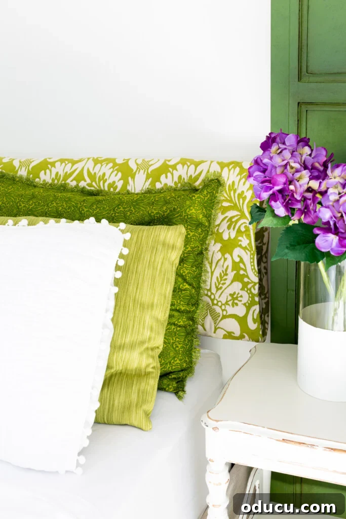 Revitalize Your Bedroom: Creative Decor Transformations 9 A cozy bed adorned with green and white bedding, complemented by a vase of fresh purple hydrangeas elegantly placed on a nearby nightstand, creating a serene bedroom setting.