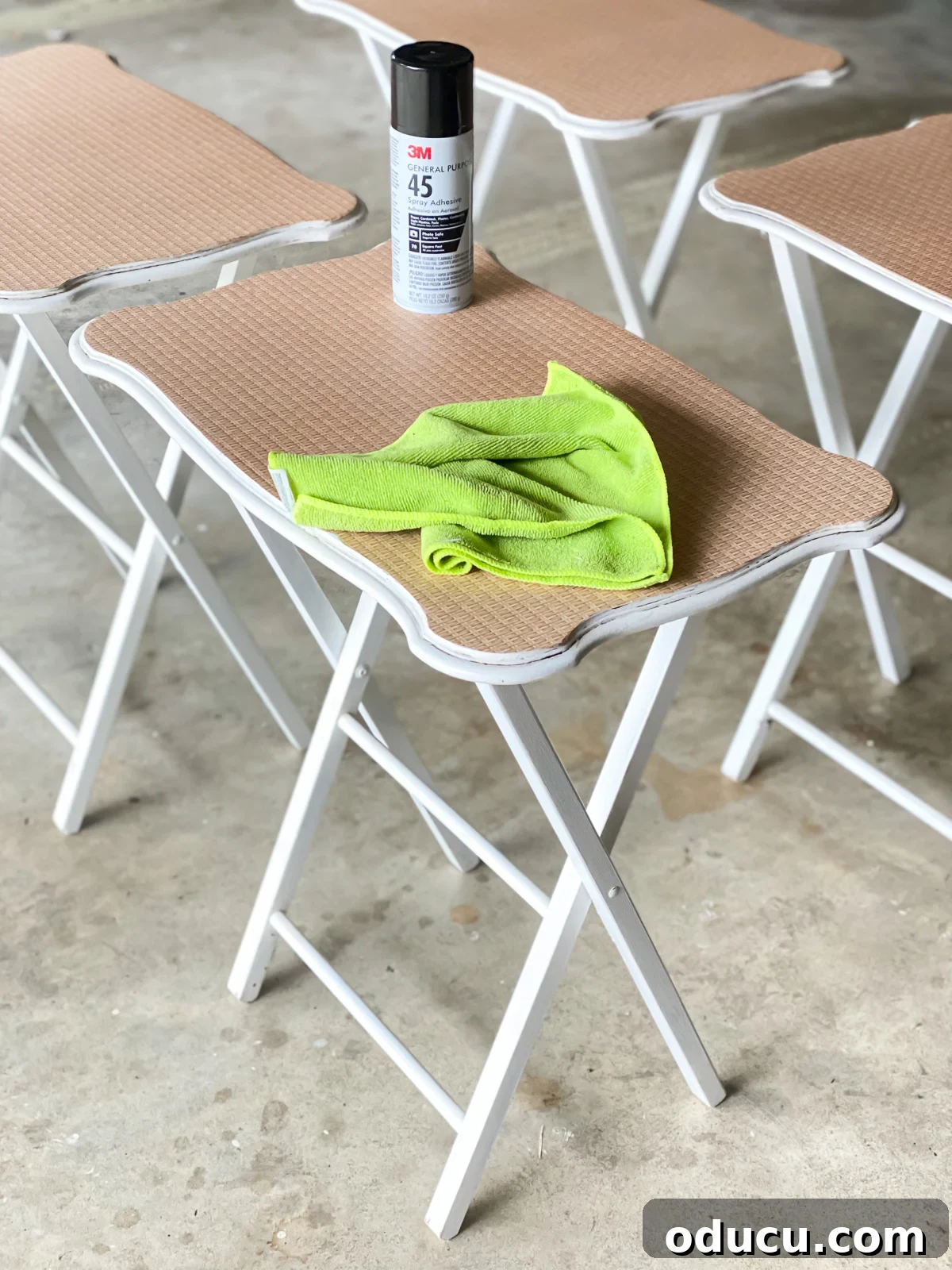 decoupage furniture - a set of tray tables being done with spray glue for a quick and easy application of decorative paper on the surface.