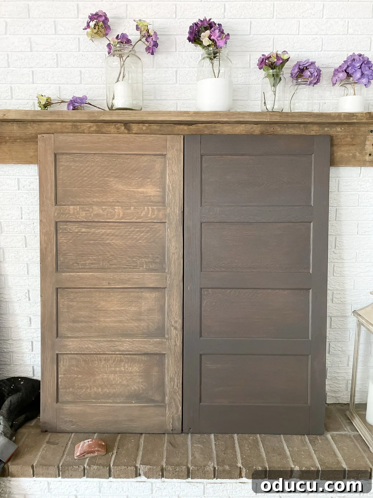 Found Treasure: My Living Room's Fireplace Cover 11 Two wood panels leaning against a fireplace wall. One is sanded to lighten it, the other is stained in a driftwood shade, showcasing the subtle differences achieved by sanding.