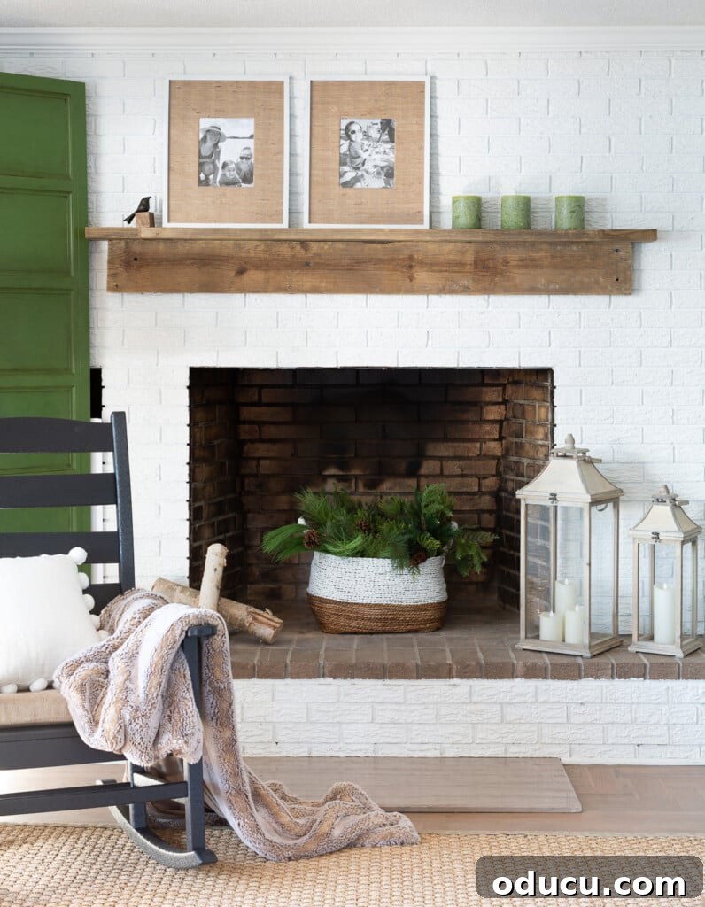 Found Treasure: My Living Room's Fireplace Cover 3 Cozy living room featuring a white brick fireplace wall adorned with a newly crafted, rustic reclaimed wood DIY mantel, embodying warmth and natural aesthetic.