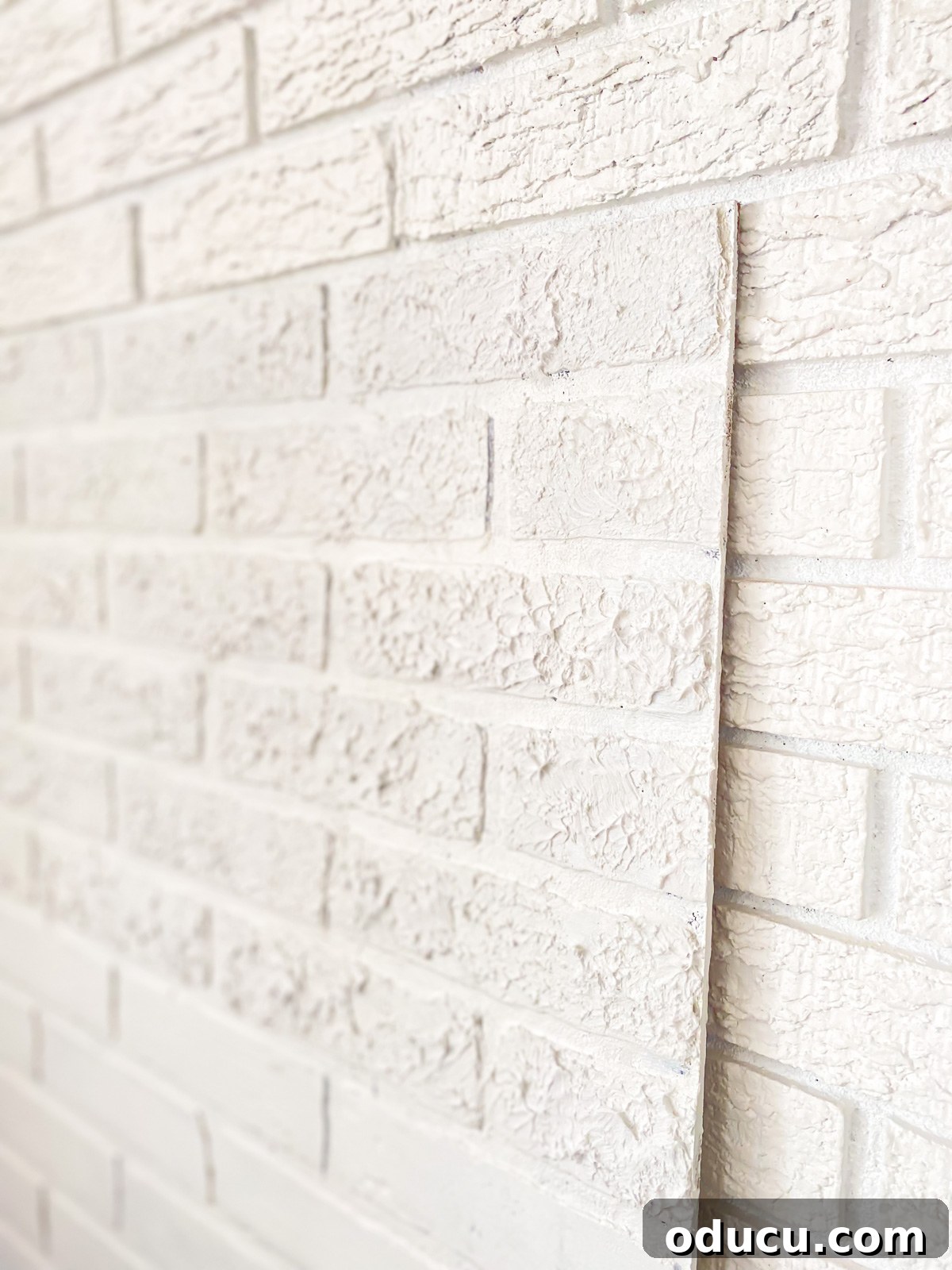 Instant Brick Wall: DIY with Faux Panels from Your Local Store 11 Image showing texture difference on a faux brick panel, with smooth bottom and textured top