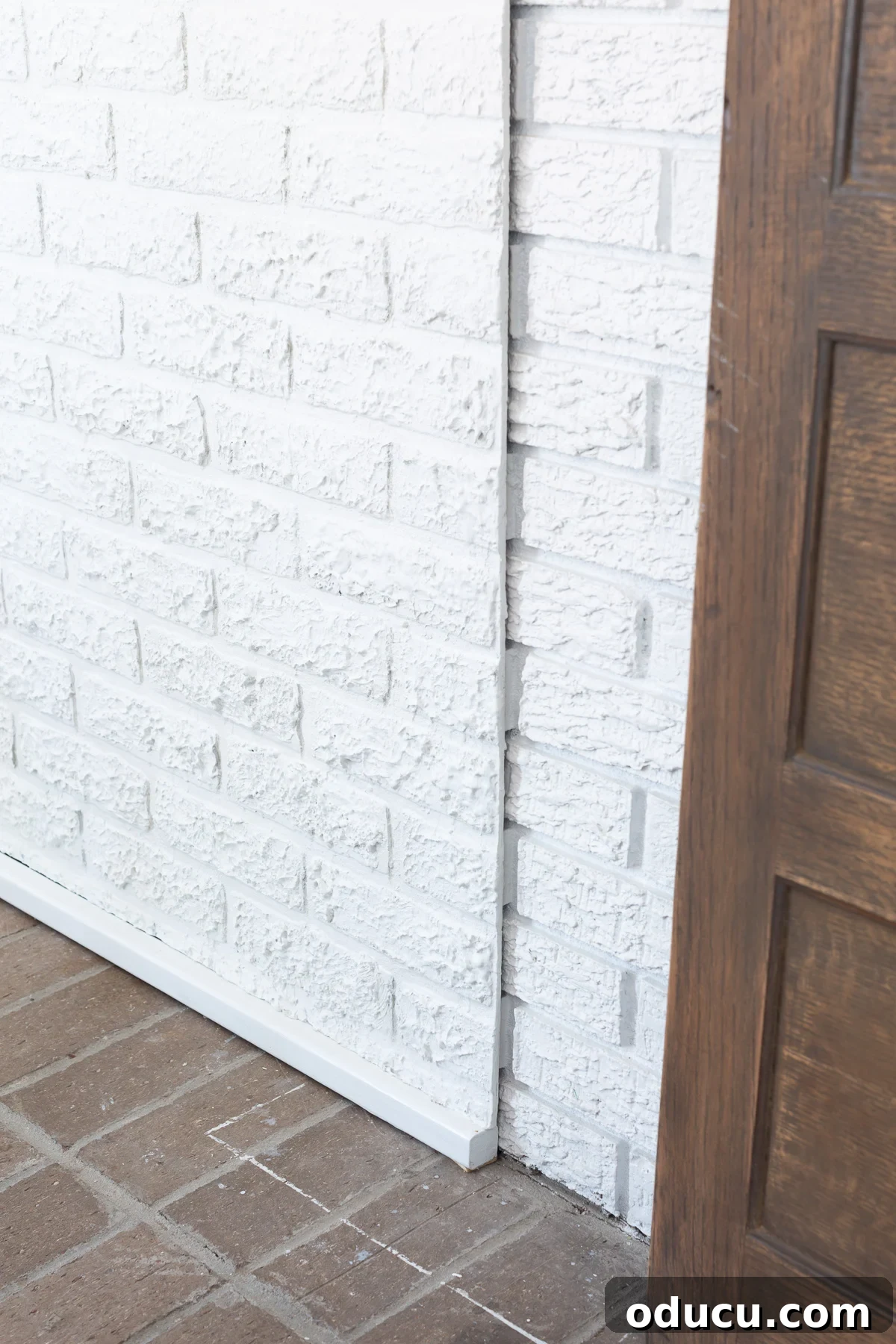Instant Brick Wall: DIY with Faux Panels from Your Local Store 13 Close up of faux brick paneling with added bottom trim to align with existing brick wall's mortar lines.